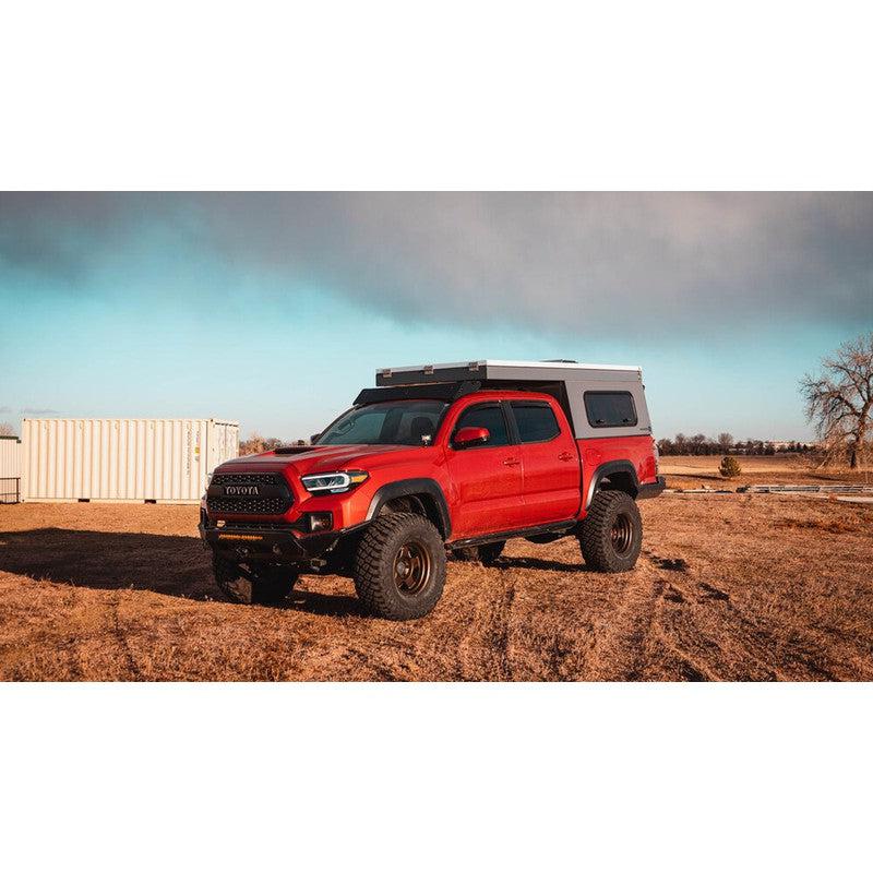 sherpa-animas-2005-2023-tacoma-camper-roof-rack-front-corner-view-on-red-tacoma-in-nature