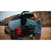 sherpa-crows-nest-truck-topper-rack-rear-corner-view-on-chevrolet-silverado-with-person-in-nature