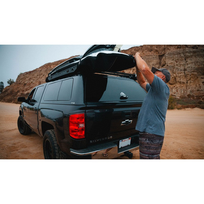 sherpa-crows-nest-truck-topper-rack-rear-corner-view-on-chevrolet-silverado-with-person-in-nature