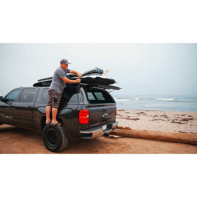 sherpa-crow-nest-truck-topper-rack-side-view-on-chevrolet-silverado-with-person-at-the-beach