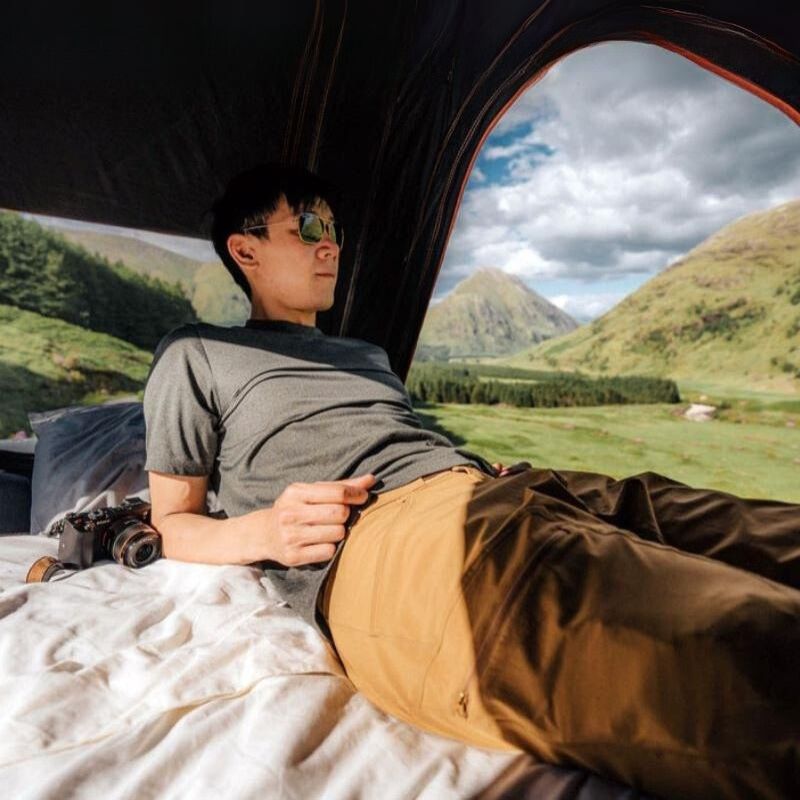 tentbox-cargo-hard-shell-roof-top-tent-black-open-interior-view-with-person-inside-in-nature