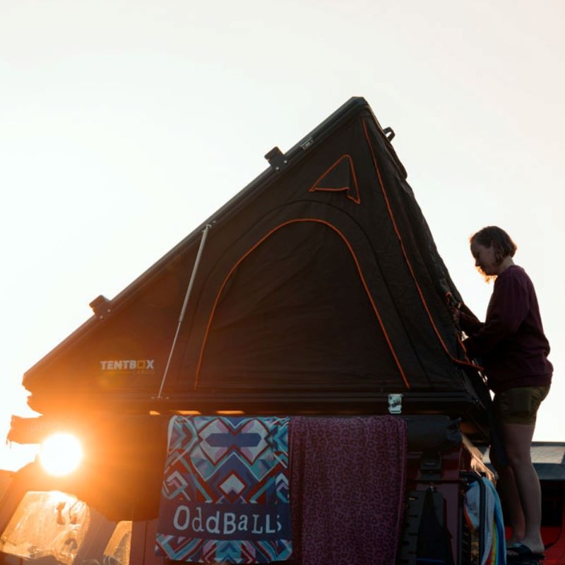 tentbox-cargo-hard-shell-roof-top-tent-black-open-side-view-with-person-in-nature