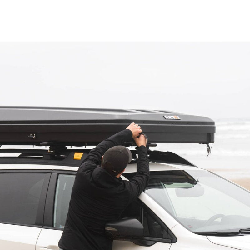 tentbox-classic-2-hard-shell-roof-top-tent-closed-side-view-on-vehicle-with-person-at-the-beach