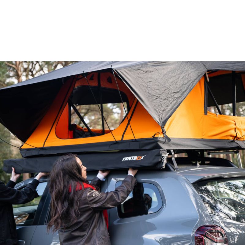 tentbox-universal-side-awning-closed-front-corner-view-on-dacia-duster-with-persons-opening-the-awning-bag