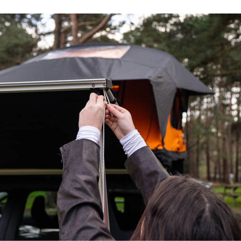 tentbox-universal-side-awning-open-close-up-view-on-vehicle-with-person-holding-rope-in-nature