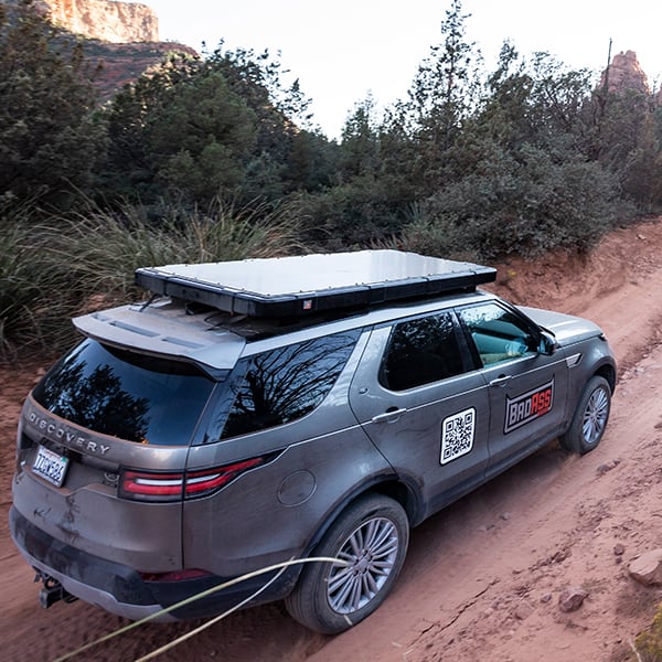 badass-tents-rugged-clamshell-roof-top-tent-closed-rear-corner-top-view-on-land-rover-discovery-5